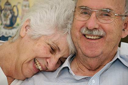 Photo of a happy senior couple, the woman with her head on his shoulder