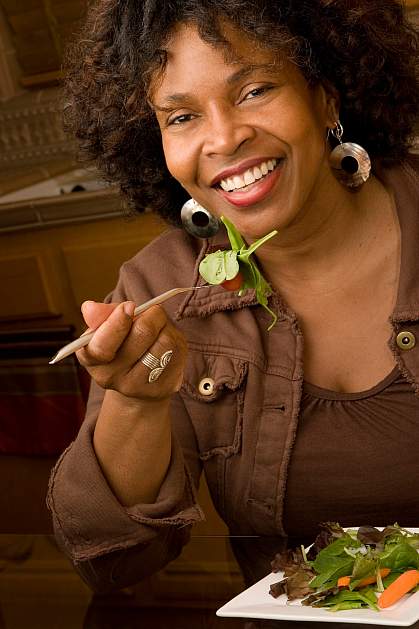 photo of a happy woman eating salad