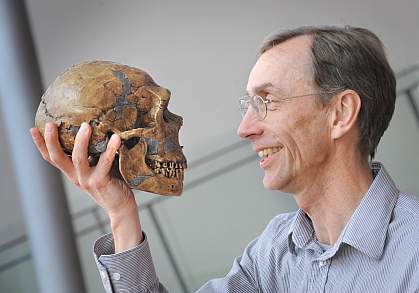 Photo of Dr. Svante Pääbo holding a Neanderthal skull