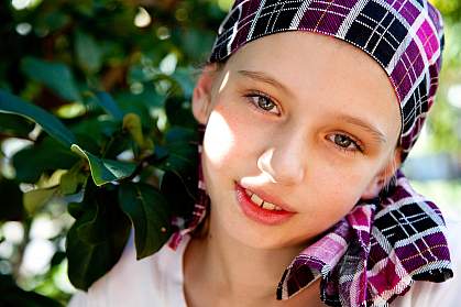 Photo of a young girl wearing a headscarf, smiling