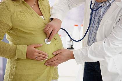 Photo of a pregnant woman with a stethoscope on her stomach