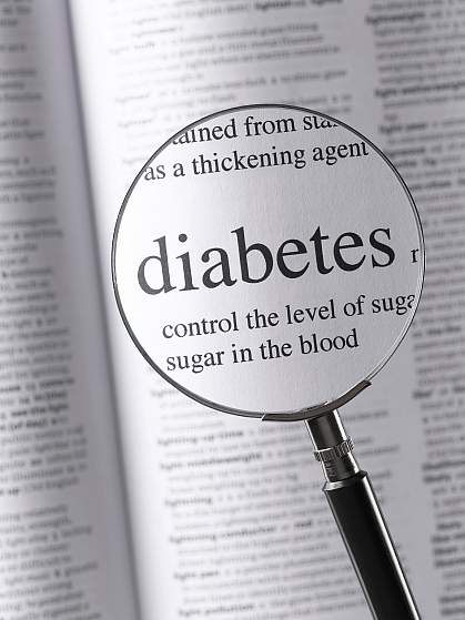 Photo of the word “diabetes” and surrounding text seen through a magnifying glass.