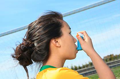 Photo of a girl using an inhaler for asthma