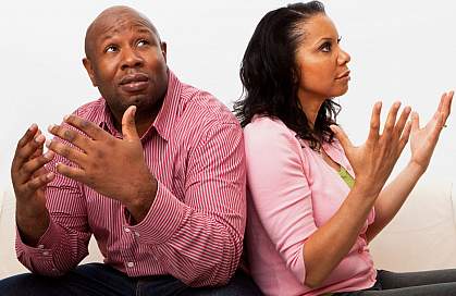 A man and woman throwing their hands up in frustration at each other.