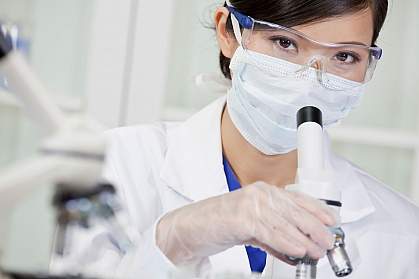 Chinese female doctor using a microscope in a laboratory.