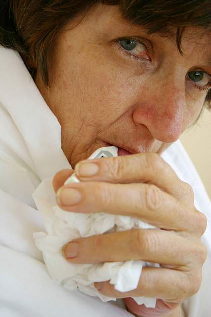 Woman holding a crumpled tissue.