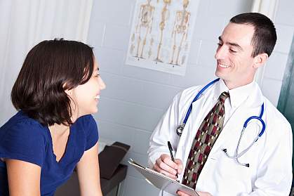 Photo of a teenage girl talking to a doctor.