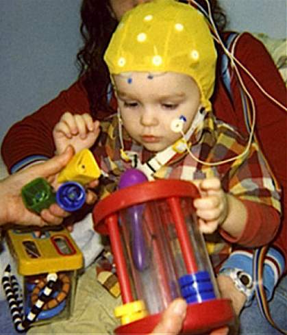 A child wearing a cap to measure brain activity