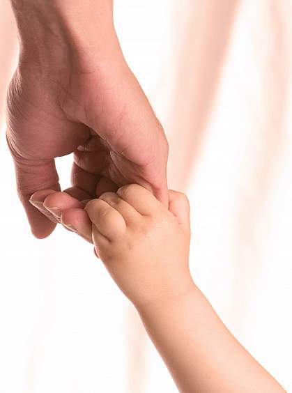 Holding hands of an adult and child.