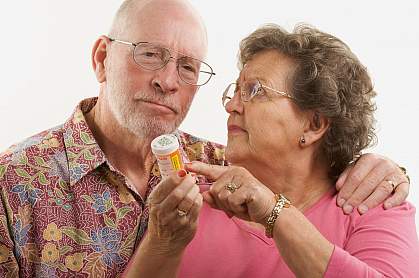 Senior couple reading a prescription bottle.