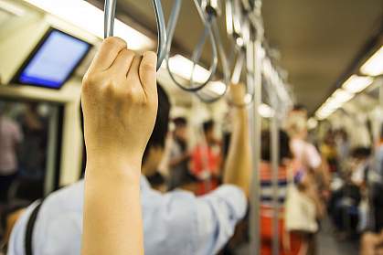 People holding onto handles on subway.