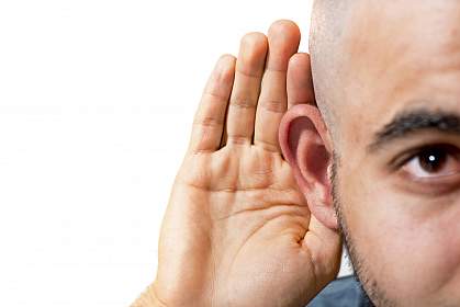Man cupping his hand to his ear.