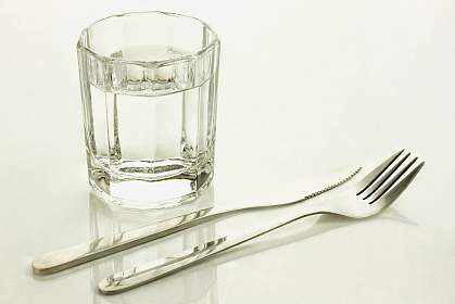 Knife and fork with a glass of water.