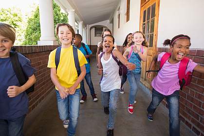 Young students running down a hall