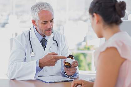Doctor explaining a bottle of pills to a patient