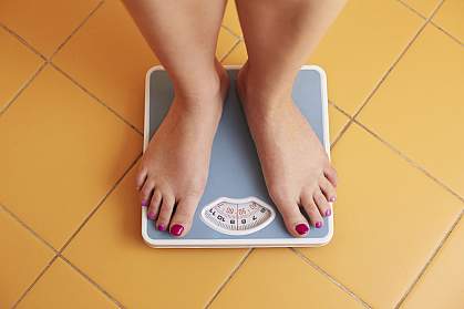 Young woman’s feet on a bathroom scale
