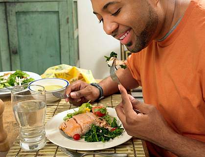 Man happily eating a salmon salad