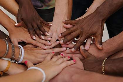 Diverse people stacking their hands together