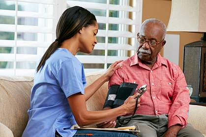 Nurse taking senior man’s blood pressure.