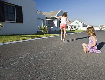 Two girls playing hopscotch on the street