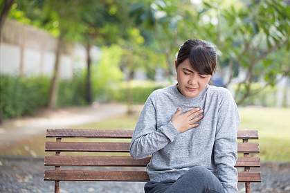 Woman on park bench with heartburn