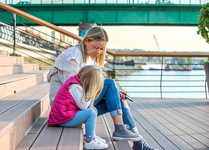 Mother and daughter sitting outside together on stairs