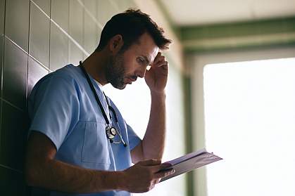 Stressed doctor reading letter