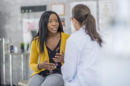 Woman describing symptoms to a doctor.