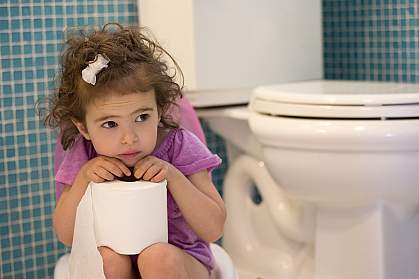 Young girl on children’s toilet.