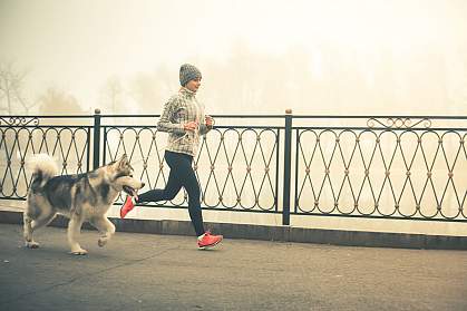 Woman jogging with a dog.