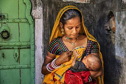 Indian woman feeding her newborn baby