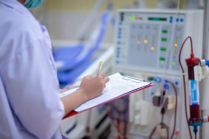 Nurse checking a dialysis machine