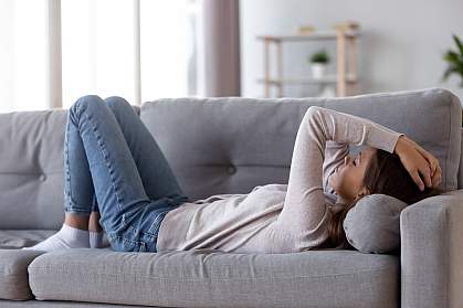 Tired young woman lying on a couch