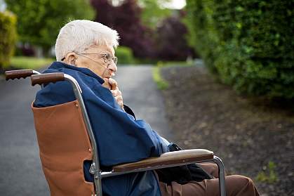 Senior man man sitting in a wheelchair outside.