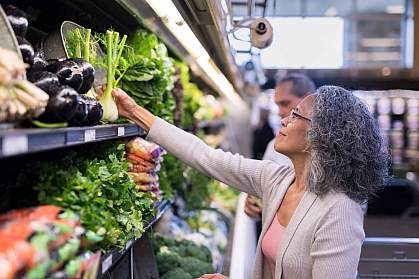 A senior couple picking out fresh produce together at the supermarket