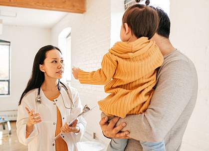 Father and toddler consulting with doctor