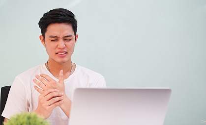 Young man in pain massaging his hand