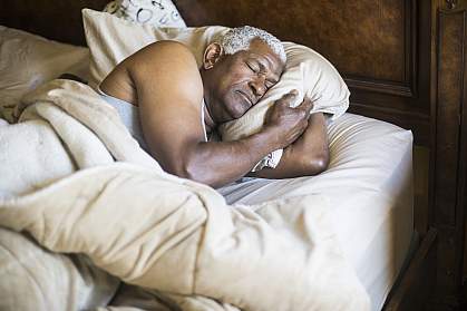 Senior African American man asleep in bed