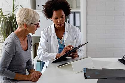 Female doctor talking with an elderly patient about test results