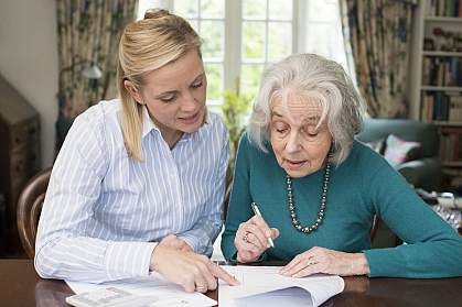 Woman helping senior with paperwork