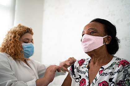 Older Black woman getting a vaccination