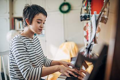 Young woman practicing piano at home