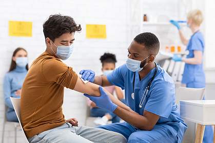 Asian male patient getting vaccinated against coronavirus in hospital