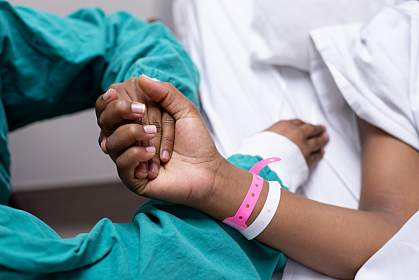 Photo of a doctor holding a patient’s hand