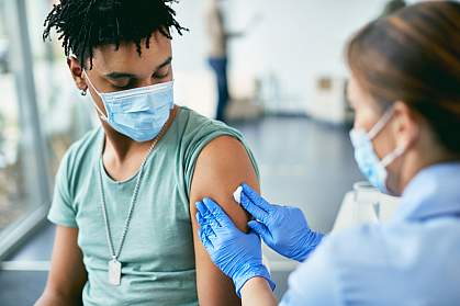 Young Black man getting vaccinated at vaccination center