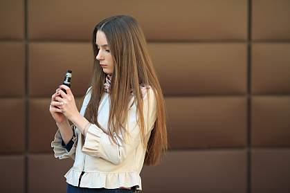 Teen looking skeptically at an electronic cigarette