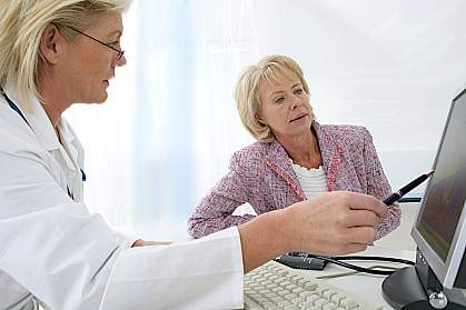 Doctor pointing to a computer screen explaining something to a patient