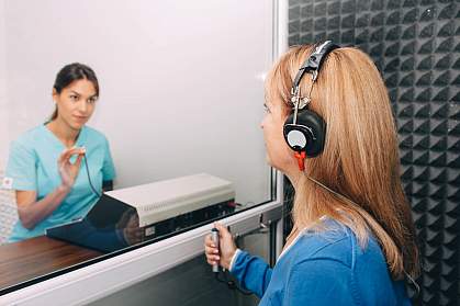 Audiologist doing a hearing exam on an older woman
