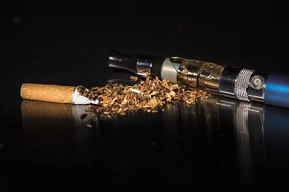 Unwrapped cigarette and e-cigarette on black background