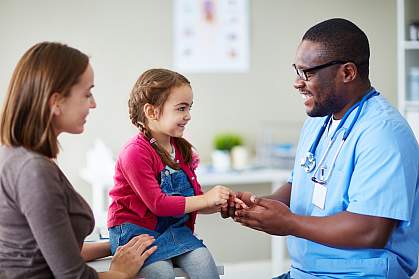Small child and doctor talking in clinic
